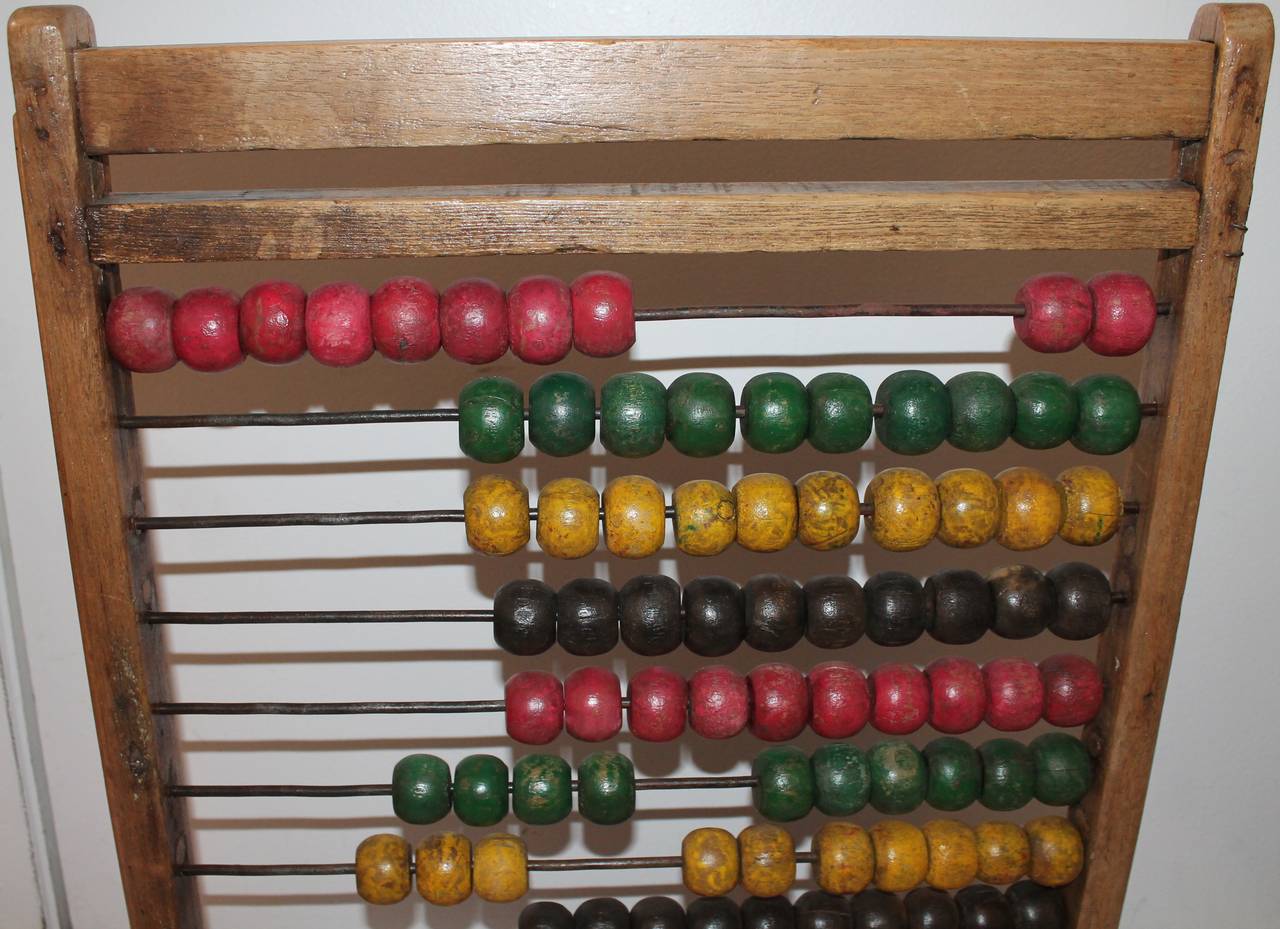 19th century abacus is a handmade tabletop on feet. It was used as a counter for children and also referred as a counting frame. This one is colorful and very handmade or handcrafted looking.