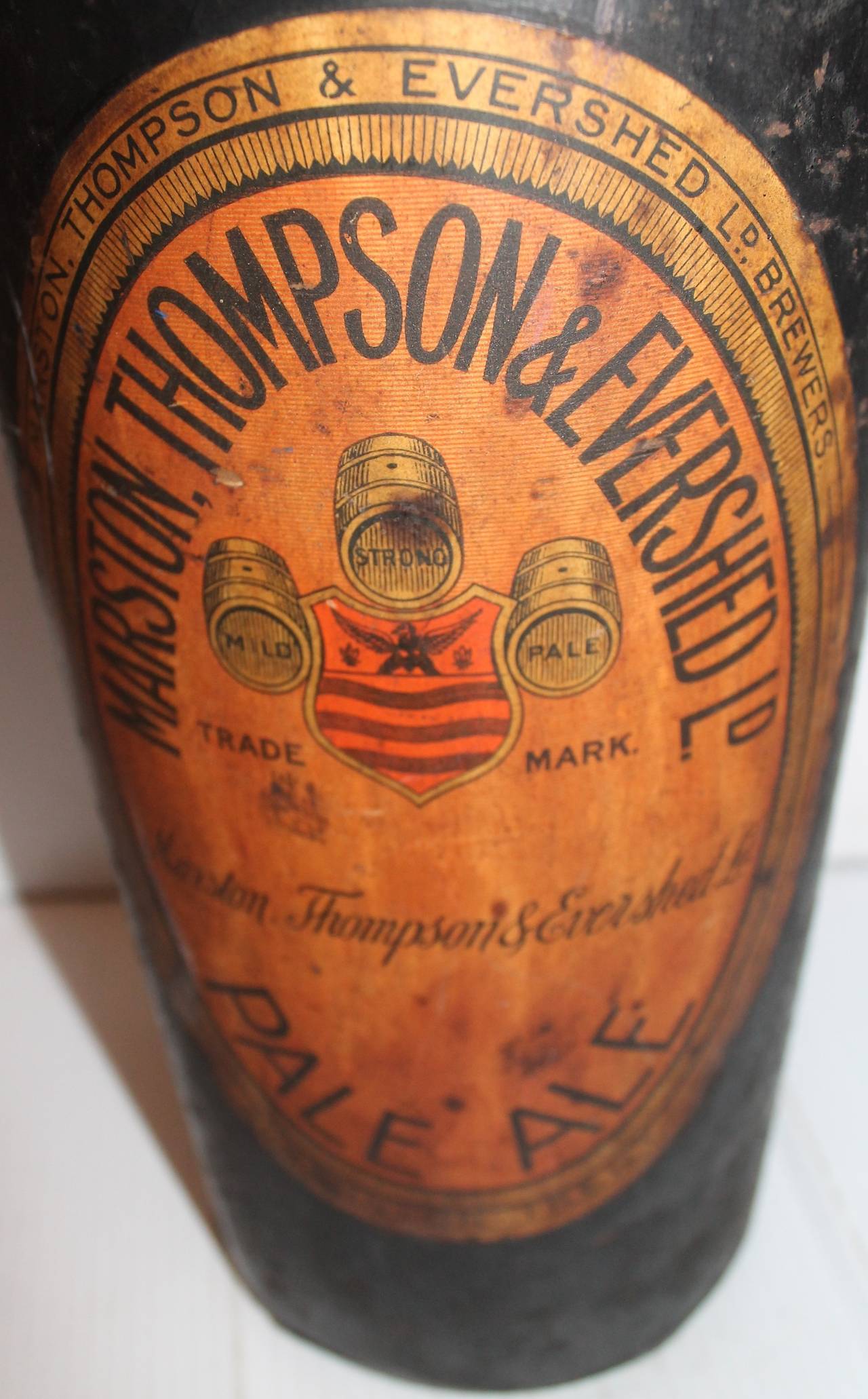 This folky 19th century pale ale monumental tin trade sign with the original paper label. The tin is original painted black surface. The condition is very good with minor crack around the neck. Amazing preservation.