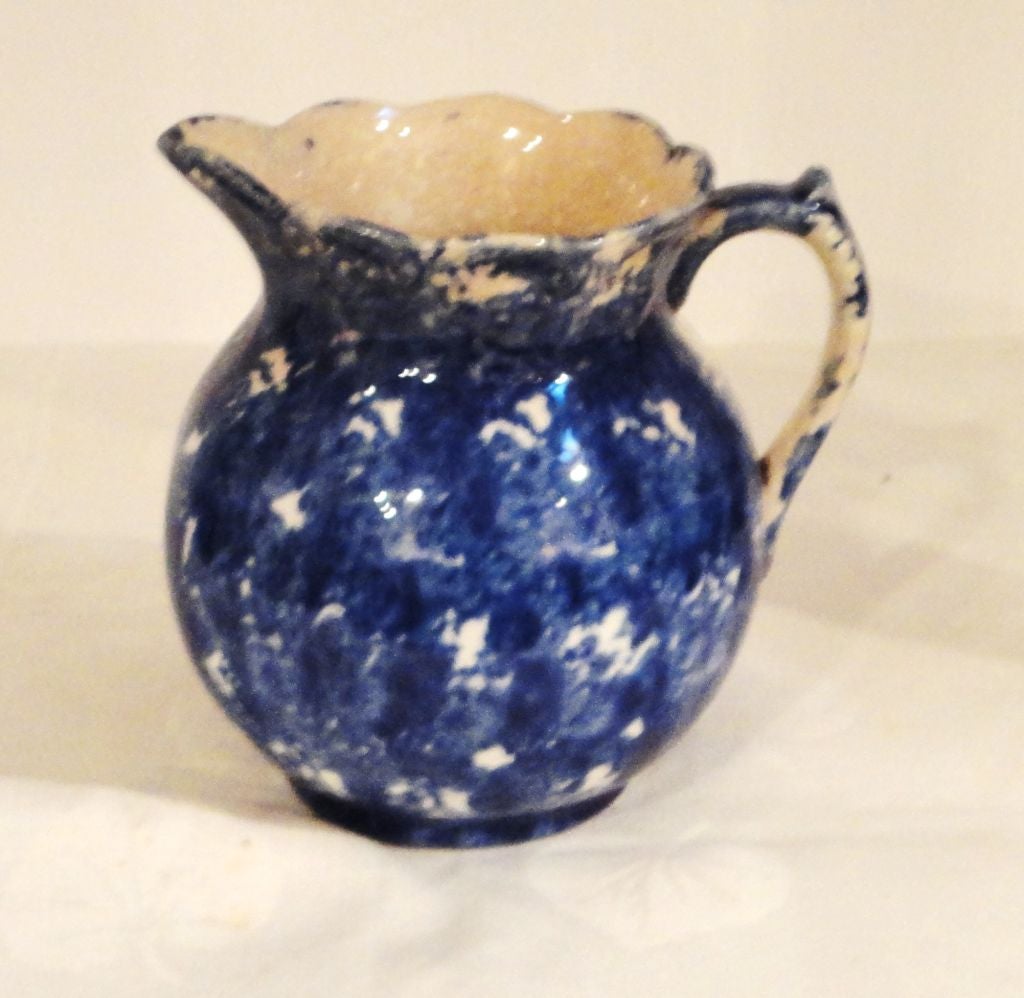 THIS ROUND UNUSUAL SHAPE SPONGE PITCHER WAS FOUND IN LANCASTER COUNTY ,PENNSYLVANIA .THE SHAPE IS SOMEWHAT UNUSUAL AND THE COLOR IS A GREAT INDIGO & WHITE .THE CONDITION IS GOOD WITH A SLIGHT YELLOWING FROM AGE ON THE INTERIOR .IT ALSO HAS A MINOR