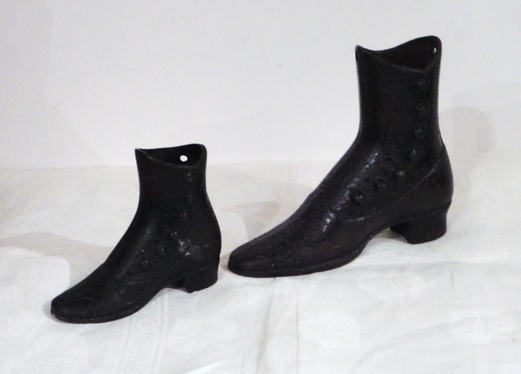 Two small and large cast iron button up boots from 19th century mannequin forms. Found in New England. Sold as a pair. Great Folk Art for a clothing store or shelf in a private collection.
         