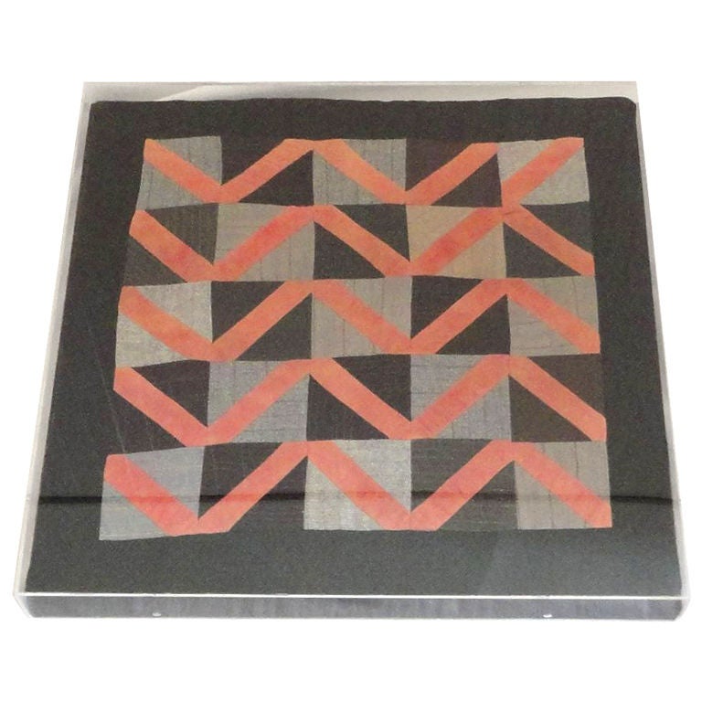 This is a very interesting pattern wool doll quilt. It has the zigzag pattern or streak of lighting within a black and grey one patch through out. The entire quilt is made from the salmon wool. It is also mounted and sewn on black linen and