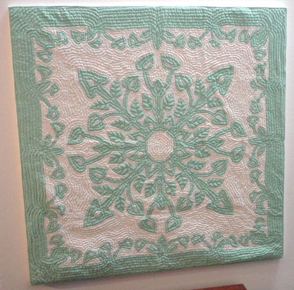 FANTASTIC AND VERY UNUSUAL MINT GREEN HAWAIIAN CRIB QUILT FROM THE THIRTIES AND MOUNTED/STRETCHED ON A WOOD FRAME AND SEWN ON LINEN.THIS GREAT GRAPHIC  AND FINELY QUILTED QUILT IS VERY RARE TO FIND IN A CRIB QUILT SIZE.THE CONDITION IS VERY GOOD AND