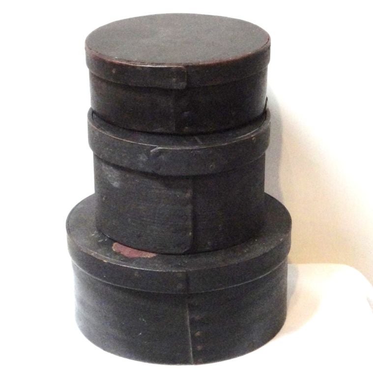 GROUP OF THREE ORIGINAL BLACK PAINTED PANTRY BOXES FROM NEW ENGLAND. THIS IS QUITE INTERESTING THE LARGE PANTRY IS DECORATED WITH A FLORAL MOTIF,VERY UNUSUAL THIS IS ALSO 19THC DECORATION.THE MIDDLE TALL PANTRY HAS WORN GILDED LETTERING 