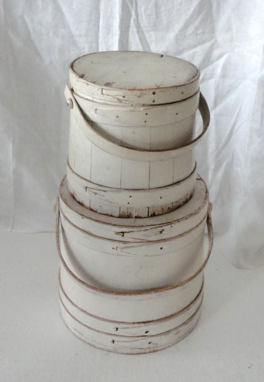 WONDERFUL ORIGINAL 19THC WHITE PAINTED FIRKIN'S FROM NEW ENGLAND.THIS STACK OF TWO BUCKETS WITH LIDS ARE IN GREAT CONDITION AND ARE SOLD AS A PAIR. SMALL IS 10 HIGH/10 DEEP. LARGE IS 12 HIGH/12 WIDE /12 DIAMETER .