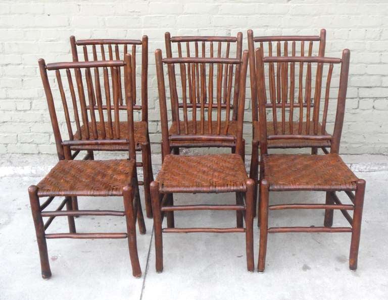 This exceptional set of six 1930's matching chairs are signed Old Hickory Furniture,  Martinsville, Indiana. With woven splint seats, these dining chairs are structurally solid and unexpectedly comfortable.