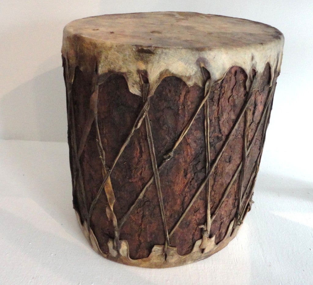 This fantastic Indian ceremonial drum has a buckskin hide over top and bottom .This hand made pueblo drum has wonderful worn surface and all original bark covering.All ties are buckskin and have a great aged patina.This is a large type drum great