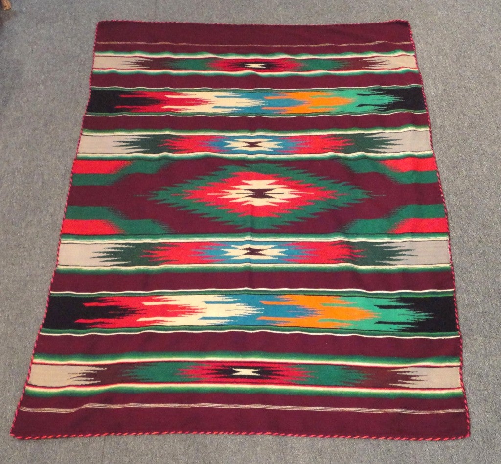 This very early Chimayo Indian weaving has a thick almost hand loomed feel,like the woven woolen homespun blankets.The colors come alive in real life,photos do no justice to this beautiful hand woven blanket or Sarape .The rope binding is also