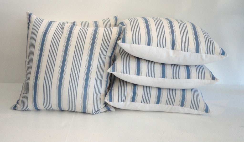 19thc fantastic faded blue & white ticking pillows with white homespun linen backing.Total of four in stock / 350. each.This ticking is in great condition with no stains or damages.