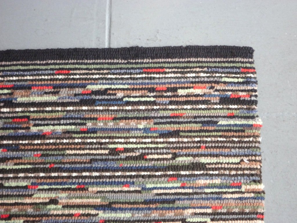 Folky and fantastic muted colors in the hit or miss pattern.This hand hooked are rug is in great condition.This rug was found in Pennsylvania and has a dark green striped border.