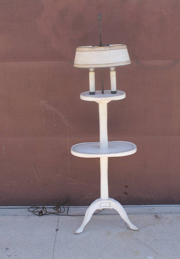 This is quite a unique floor lamp with white painted wood and gold trim. The tin shade is in a painted white and gold trim. The electrical fixtures on top are in brass and switch too. The cord is in a rewired silk cord. Condition is very good and