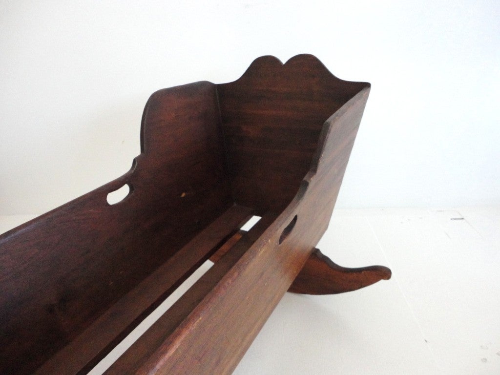 This wonderful handmade 19thc dovetailed walnut cradle has great details and workmanship.On both sides of the top of the cradle has finger cut outs,as you can see in the photos.The top and the base of the cradle has wonderful scallop cut outs. The