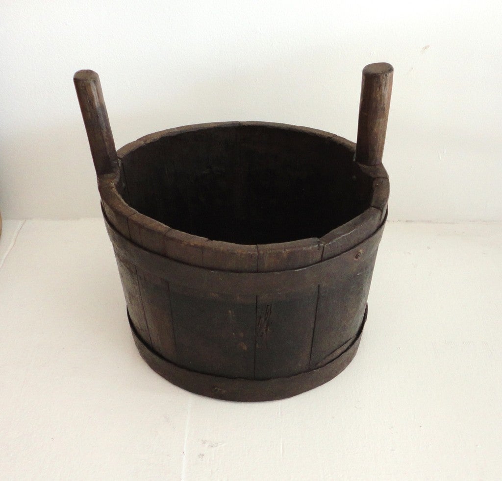 This fine Primitive handmade double handled bucket was originally from New England, and probably used on a farm or 18th century log cabin. This rustic wooden bucket has the original iron bands and is very sturdy and strong for holding fruit or