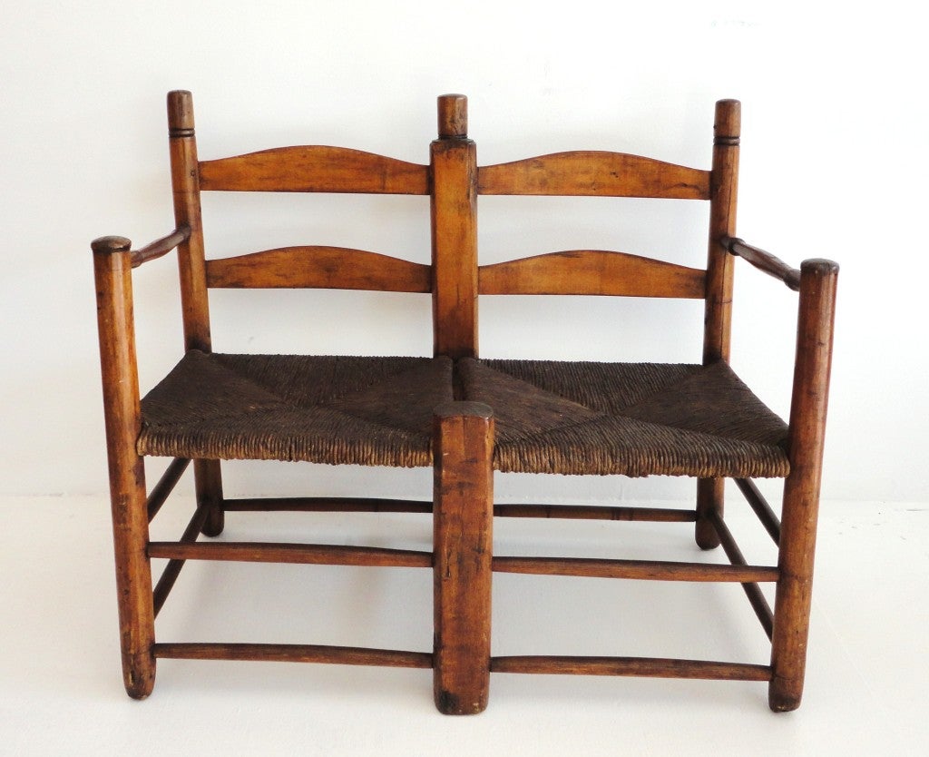 Early 19thc settee from Pennsylvania ,some would call buggy seat.This folky and early primitive sits two adults in a love seat format style.This is a double ladder back with a arm rest on both sides.Great in house or for a country porch.The