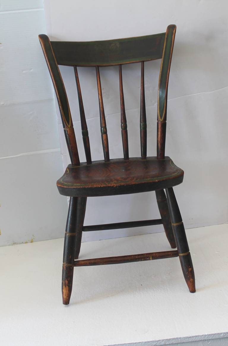 This is such a fantastic untouched worn surface children's original painted New England Windsor chair . It retains the pin striped painted and stenciled surface . The patina is the very best and the chair is in sturdy condition.