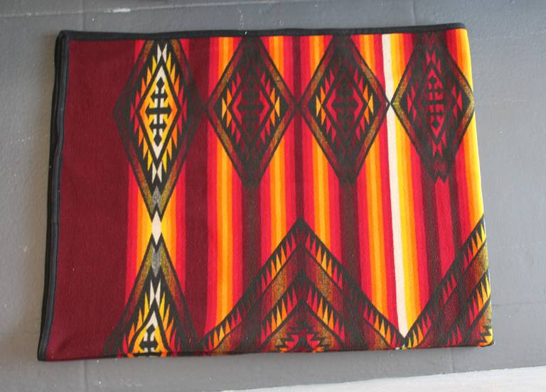 This is a real show stopper Pendleton camp blanket. The Indian sunset colors are amazing and condition is even better. It is an early purple label, Beaver State worn silk label in the lower right hand corner. The condition is so good and it is a