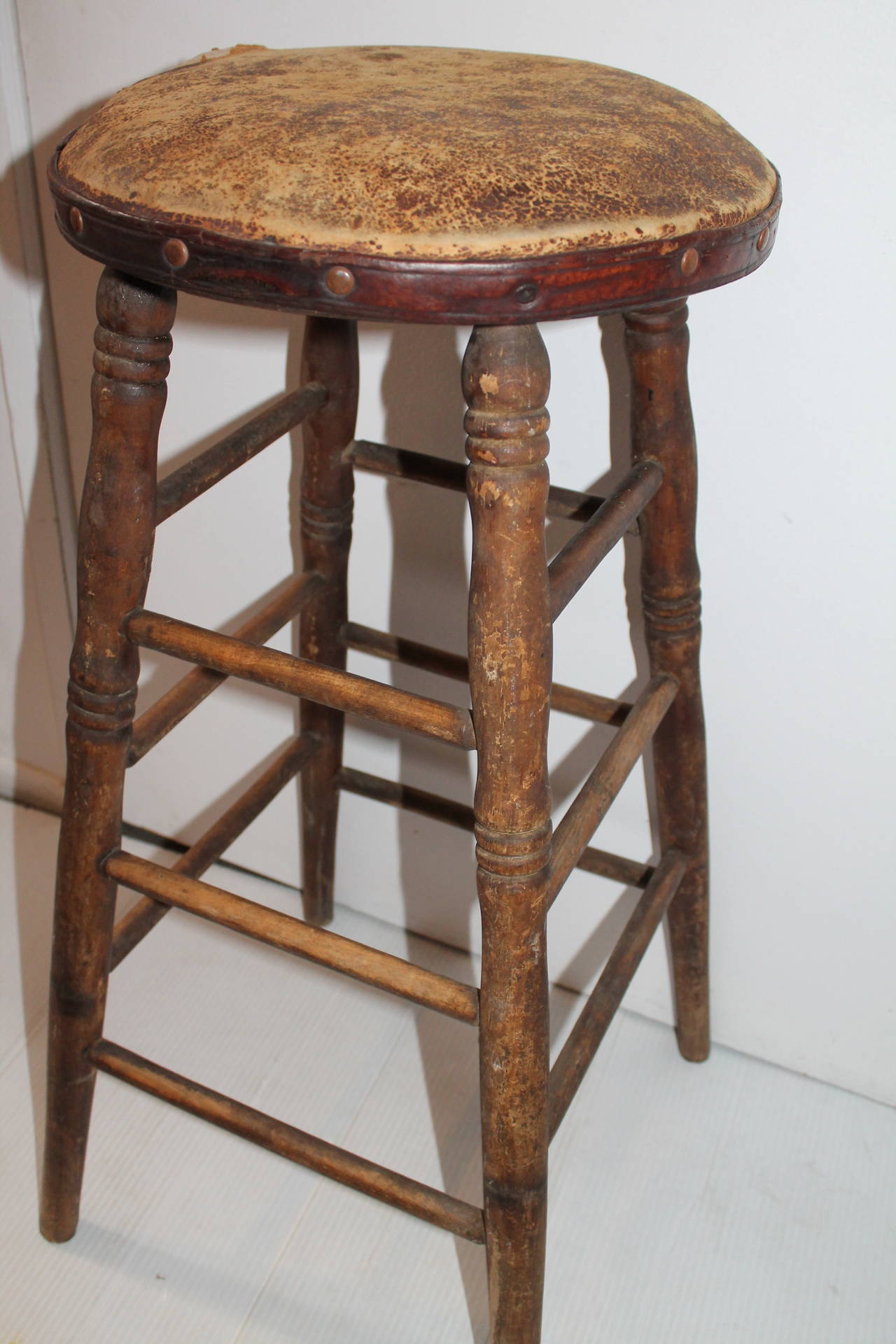 This is a old leather seat on this Industrial stool from a old shoe factory. The condition is good with a worn leather seat and pine base.
