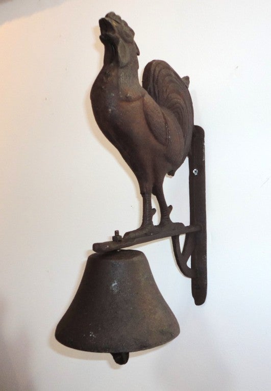 Fantastic cast iron wall mount dinner bell with full body iron rooster attached.This heavy solid cast iron wall mount rooster and dinner bell with iron ringer.This folky ,cool dinner bell was more then likely used on the farm to call the help for