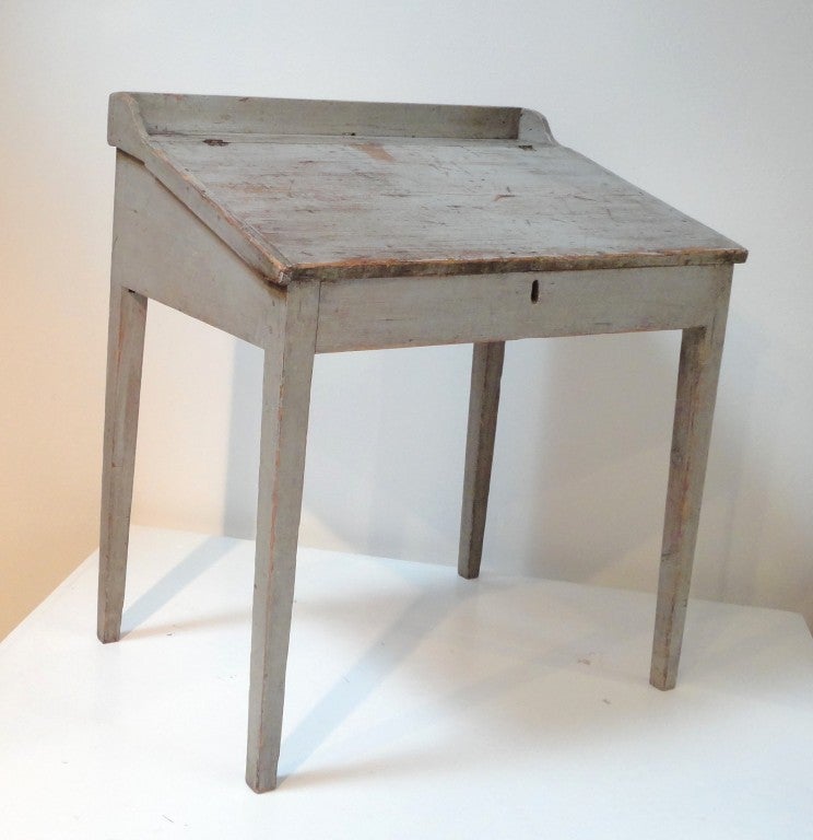Fantastic early 19thc original blue/grey slant top primitive desk.This desk has the best old worn surface.The interior has two little drawers with original shaker style brass pulls and dovetailed construction.The taper legs are wonderful form.The