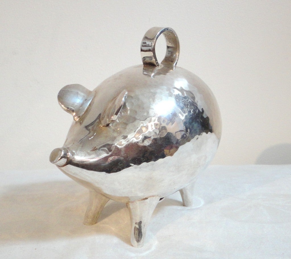 Fantastic hand made sterling silver ,heavy ,folky piggy bank.This charming pig is all hand hammered with a large loop at the top and a silver cap that unscrews to open to remove the coins.The tails is silver wire and curly.This is such a great piece