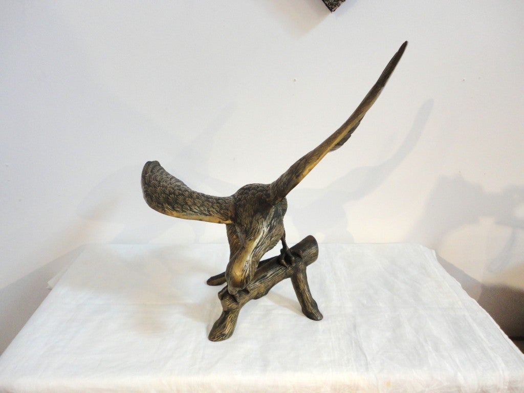 Fantastic large brass sculpture of an eagle with the wings spread on a tree branch. This full body eagle and branch has a wonderful worn patina. This wonderful molded folk art is unsigned and is in wonderful condition.