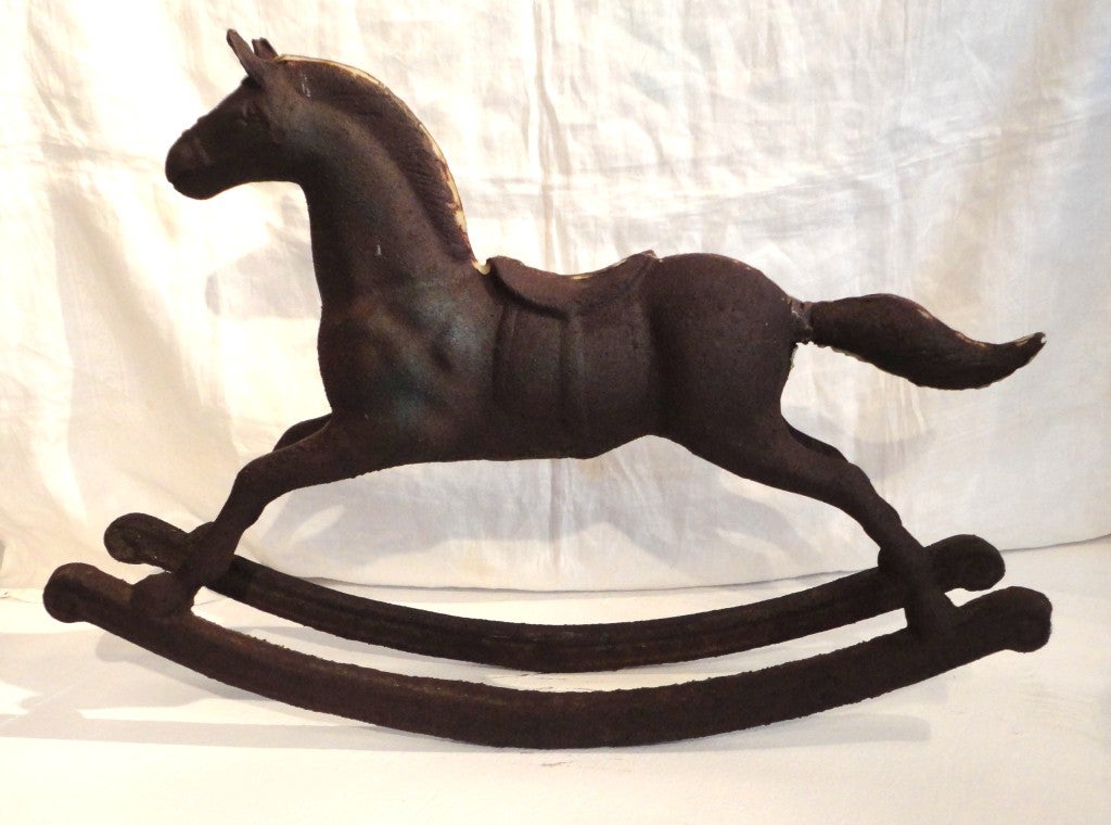 Fantastic 19th century large cast iron carrousel rocking horse with fragments of paint surface. This monument horse is in very good condition and sturdy. The tail has been re-welded many years ago. The body had robin egg blue and the main was in old