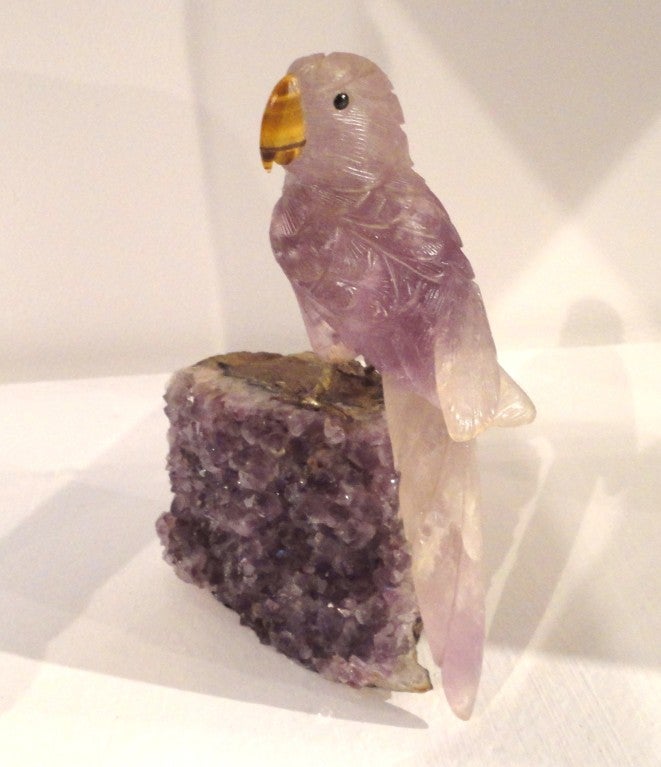 This folk art hand carved amethyst rock crystal bird has a hand carved tiger eye for a beak.This fantastic bird sits on top of a raw amethyst crystal slab and has sterling silver feet .This is a two piece sculpture.The condition is very good.