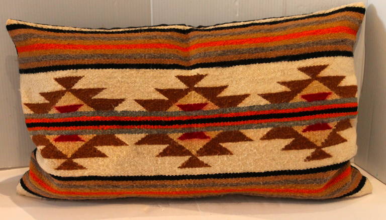 This is a single saddle blanket pillow with vibrant colors and design. The backing is in a dark brown cotton linen.