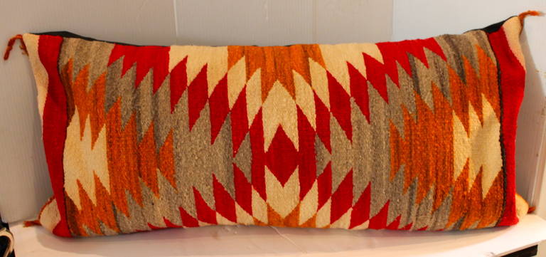 This early 20th century weaving has specific fall colors and a wonderful broken star Indian pattern. This large bolster pillow is in great condition and has a cotton linen backing. Insert is down and feather fill.