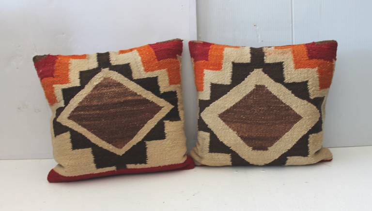 Fantastic and early pair of Navajo Indian weaving pillows. This vibrant and simple pattern weaving has brown cotton linen backing. Sold as a pair. Inserts are down and feather fill.