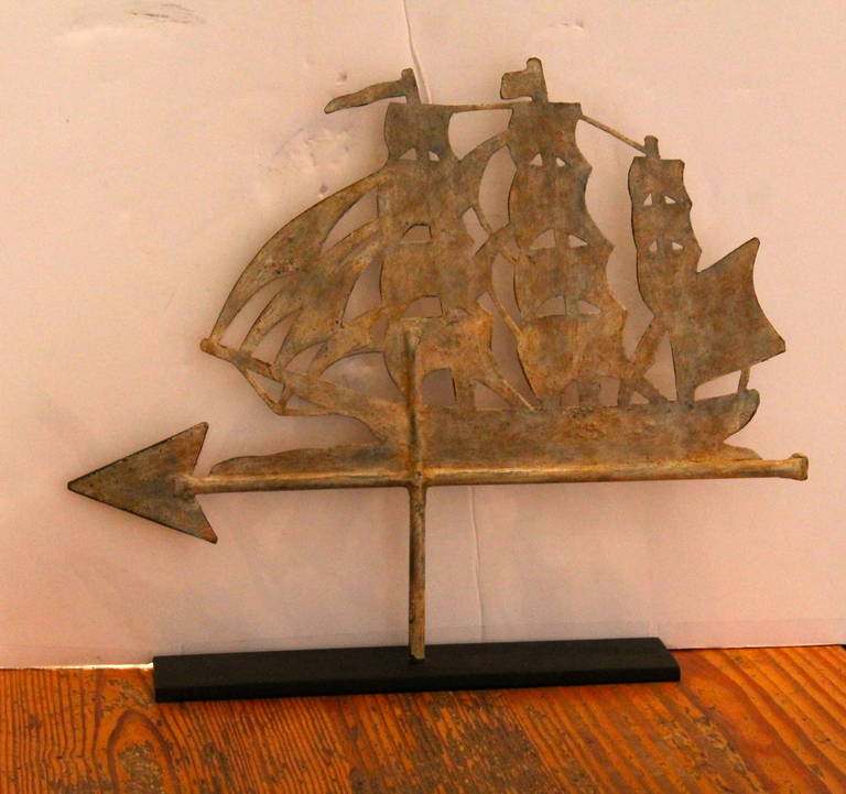 This wonderful painted sailing ship weathervane has a great worn patina on the painted cream surface. It is on a custom-made black iron stand. The condition is very good.