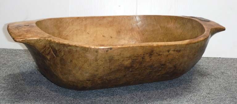 Amazing early hand carved dough bowl with handles and fantastic patina. This bowl is in wonderful condition with some early tin repairs . Great surface ! This is one of the largest and deep wood trencher we have ever seen .Great for collection of
