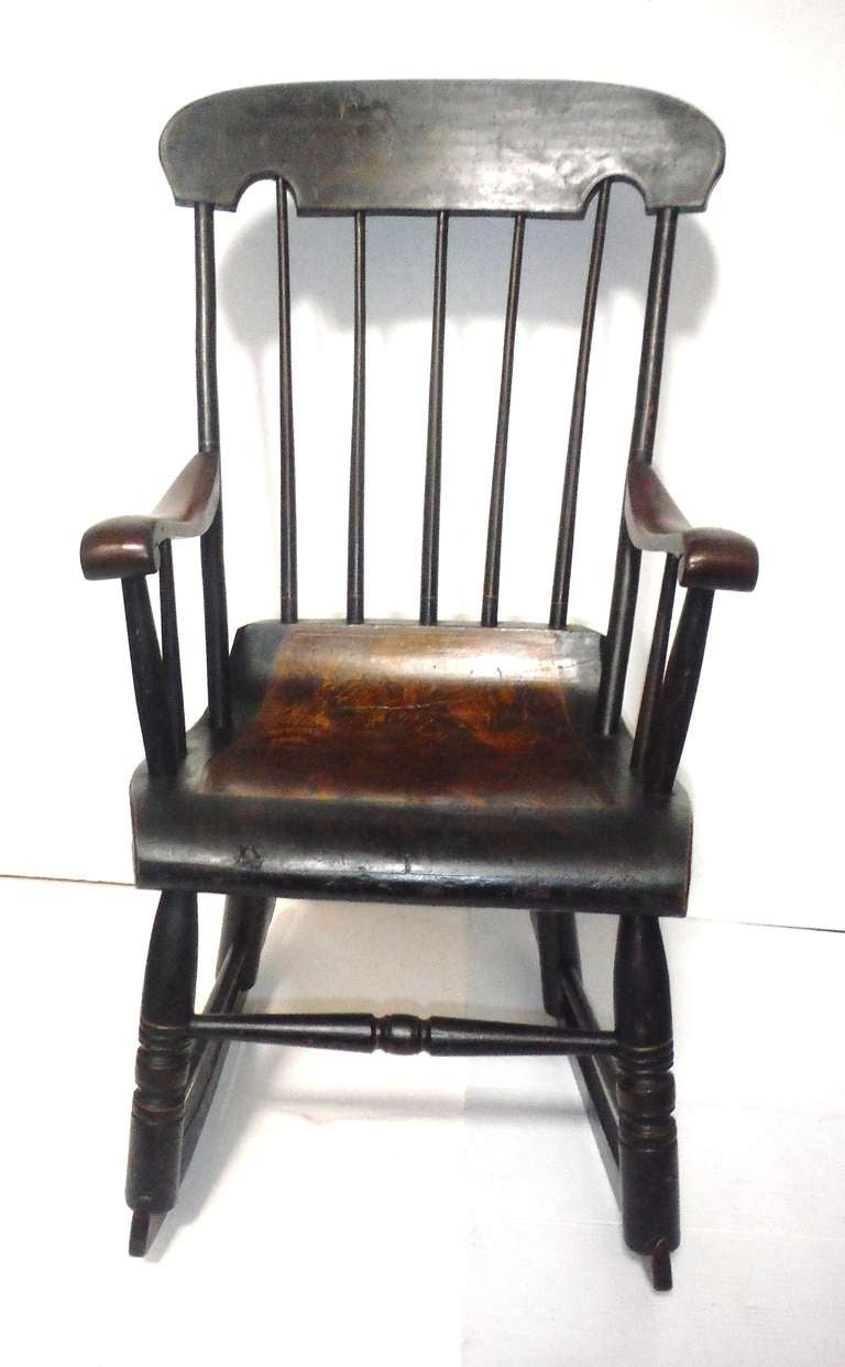 This early 19th century original paint decorated rocking chair is constructed of sturdy pine with a shaped rectangular crest rail above a spindle back with scroll arms.

These sponge decorated rockers were a popular appointment in nurseries