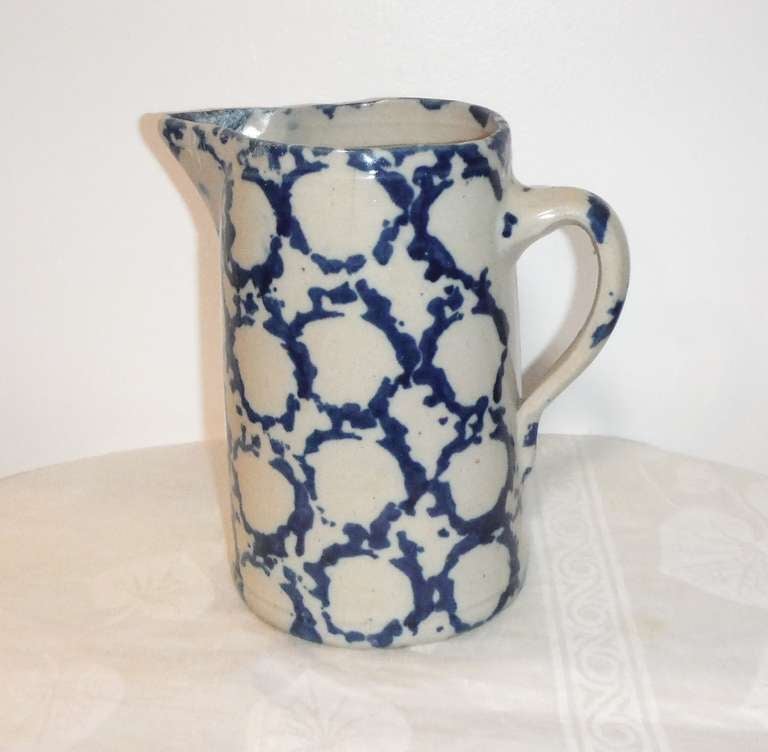 Early 19th century and most unusual dark indigo blue patterned in a circular form. This pitcher is in good condition with minor age marks. This is a very heavy stone ware pitcher.