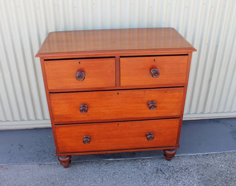 This early 19th century mahogany and walnut English chest of drawers has the original bun feet and dovetailed construction. This sweet size chest works great as an end table or bedside chest of drawers. This condition is pristine. This is a one of a