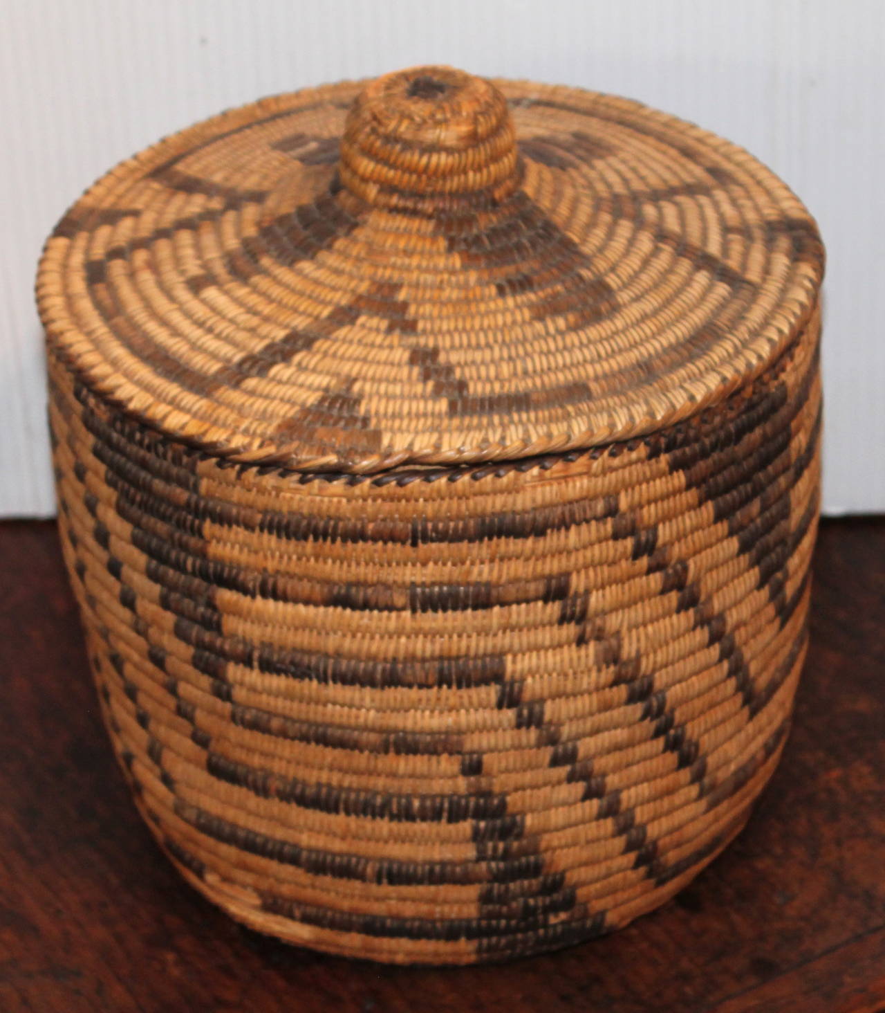 This is a fantastic geometric and lided Papago Indian basket.The condition is very good with minor wear on the base and a little wear on the top of the lid.The wear is consistent with age .