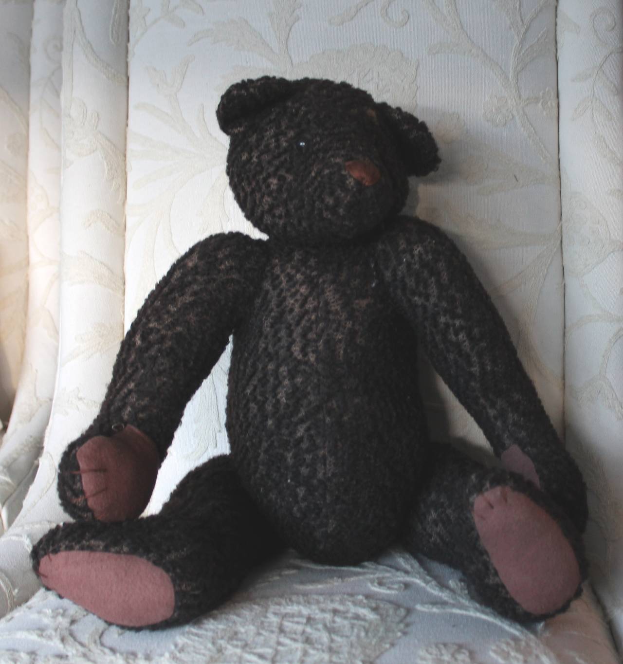 This 1930s black mohair teddy bear has glass eyes and is all movable arms, legs and head. It is most likely a Knickerbocker black bear. Just in time for the holidays! The condition is very good with wear in the expected areas.