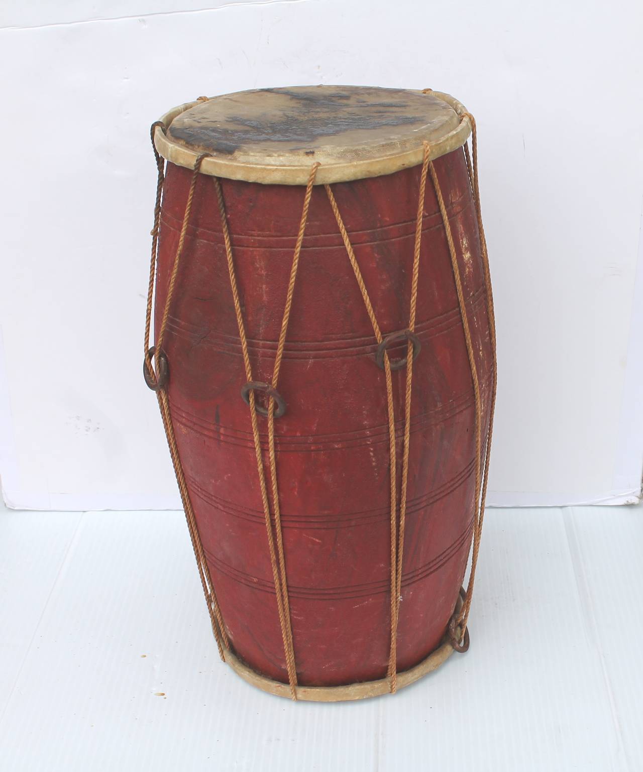 This is quite rare to find and such an odd and early probably Pueblo ceremonial drum in a wonderful untouched red surface paint. The original hide is on the top and base. Fantastic patina and condition.