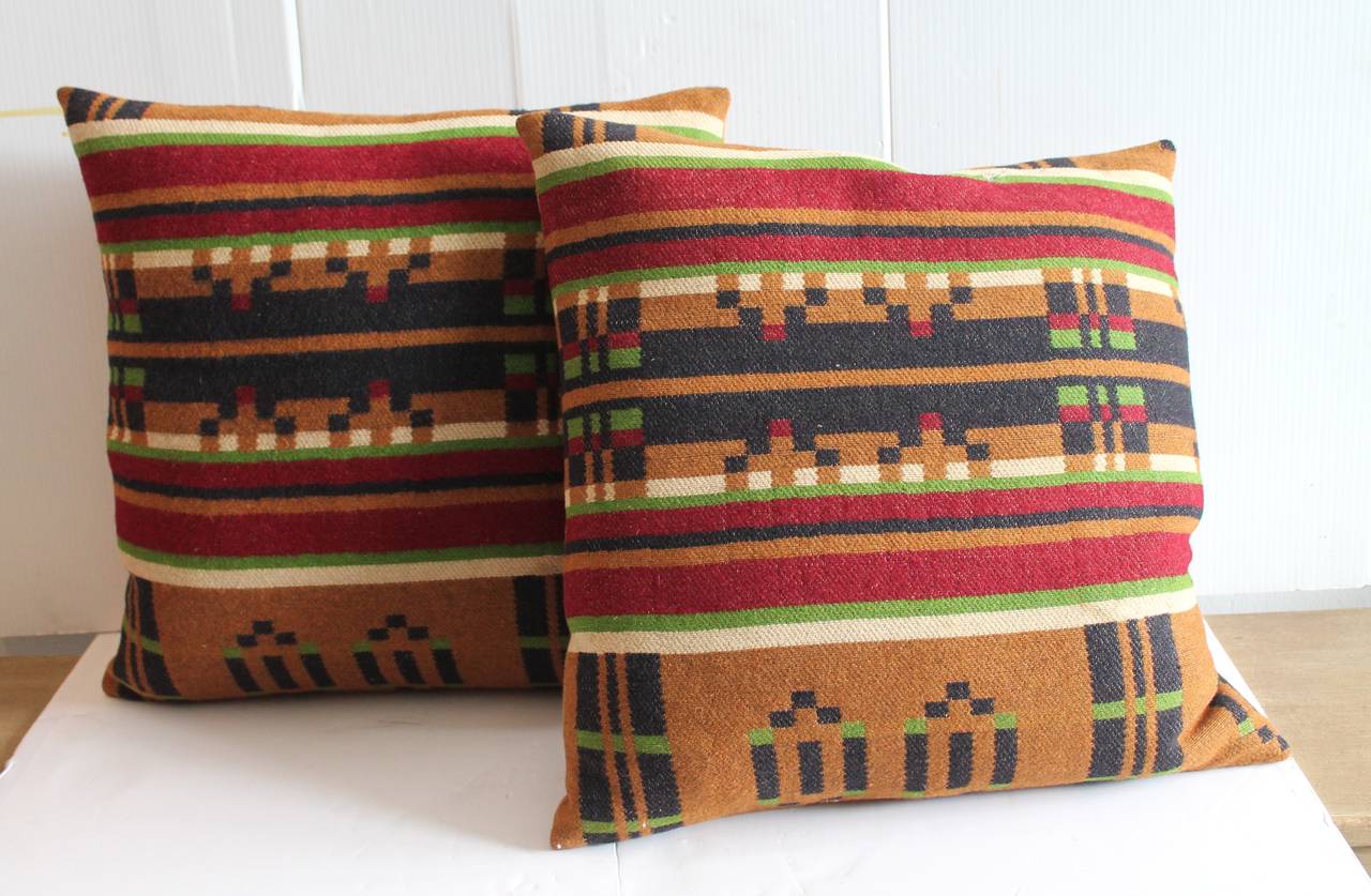 This pair of horse blanket pillows have wonderful color and a most unusual geometric pattern. Sold as a pair. The backing is in a tan cotton linen. Down and feather fill.