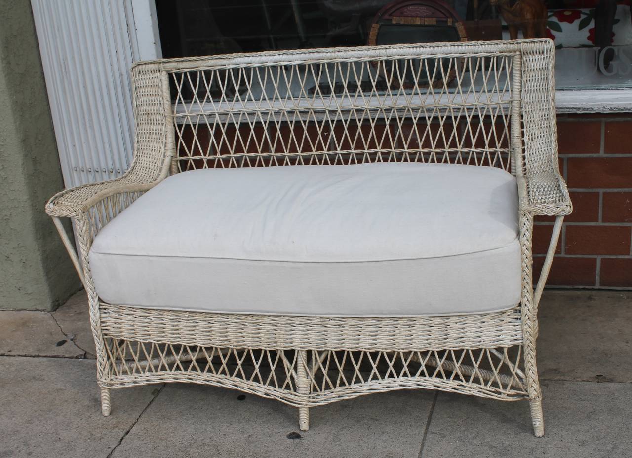 This wonderful original painted wicker sofa has a custom-made washable cushion in canvas linen. The condition is very good and sturdy. Great indoors or out. This was found in New England.