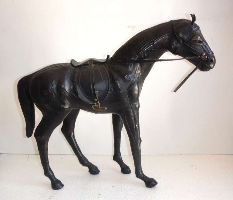 This handsome leather horse statue is completely handcrafted with outstanding detail including custom stitched saddle, brass stirrups, leather bridle, glass eyes and brass tacking accents.

The horse also shows outstanding muscular definition with