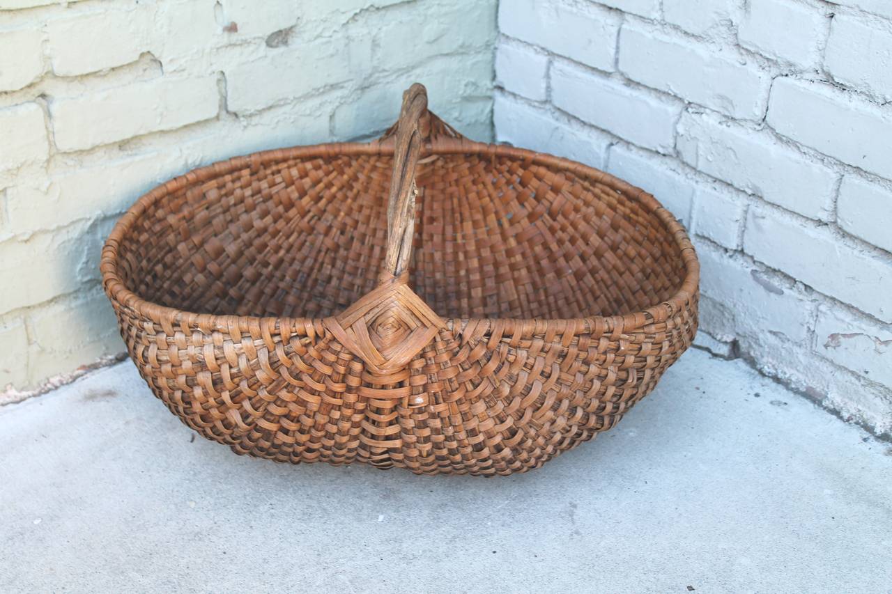 This early vegetable or fruit gathering basket was found in Pennsylvania and has a wonderful untouched surface. The condition is very good and has a twig wrapped handle.