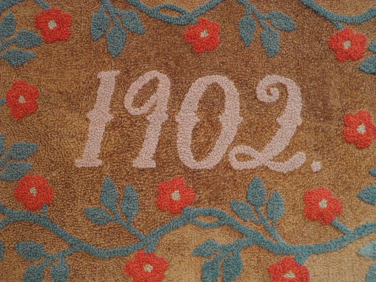 Fantastic hand hooked 1902 rug sewn on linen & on a stretcher mount. Wonderful vine border in red & green on a hemp ground. The 1902 date  are in mauve color hooked in the rug. This rug was found in Pennsylvania and condition is very good.