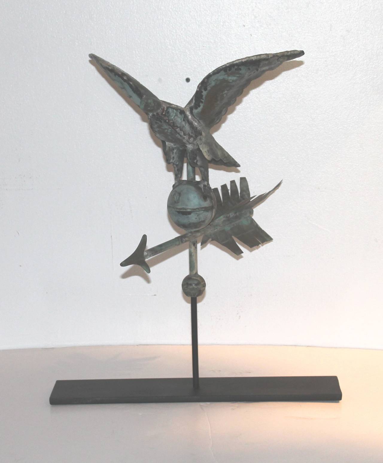 This amazing small-scale rare 19th century eagle weather vane sits on top of the unusual arrow in a verdigris copper patina. The nose is in zinc and so is the tip of the arrow. This vane sits on a custom-made iron stand. Great addition to any Folk