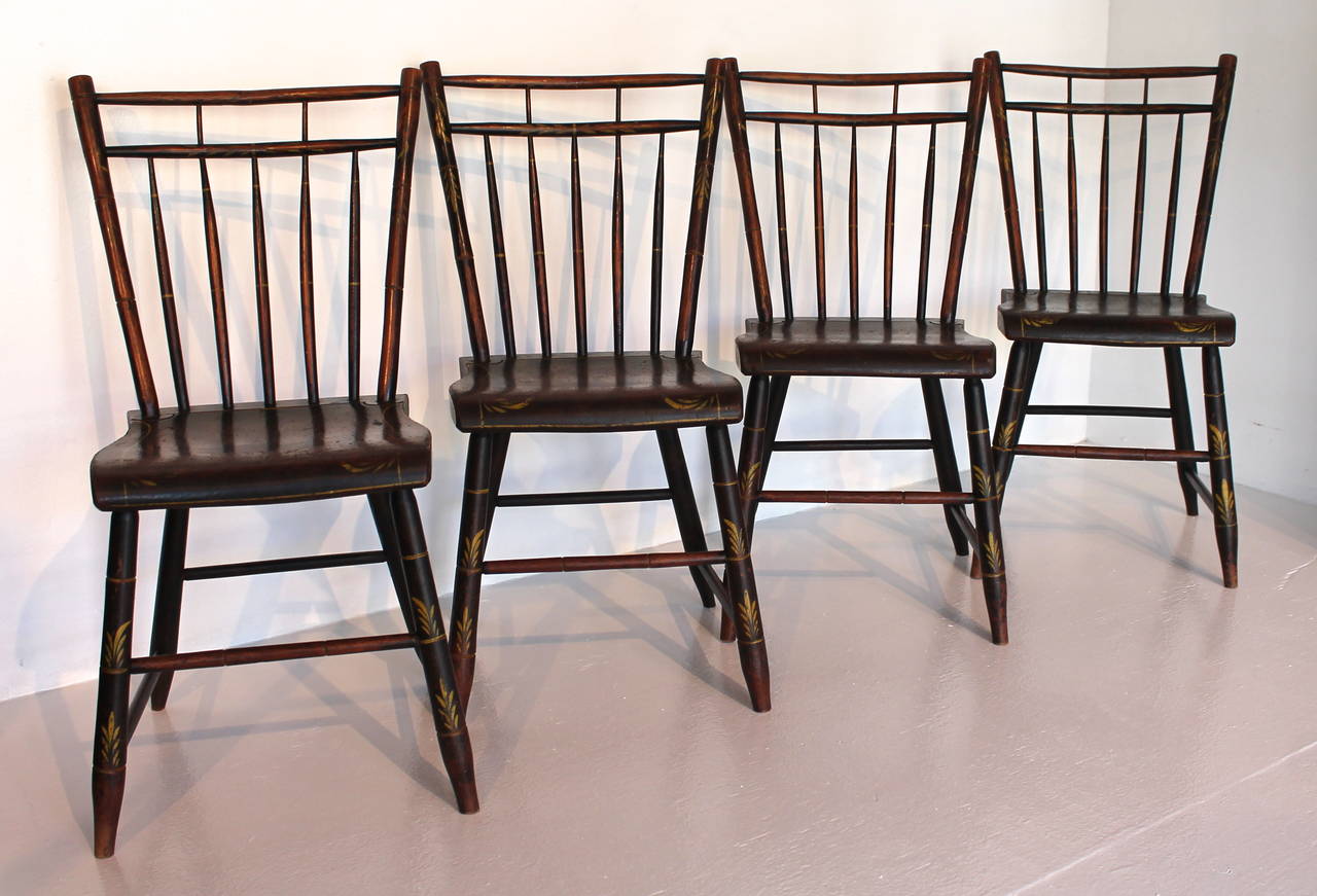 This amazing set of black over red paint decorated Windsor chairs are in great untouched condition. These chairs were found in Pennsylvania and are probably Lancaster or Berks County. The wonderful mustard out line decoration is up the side rods and