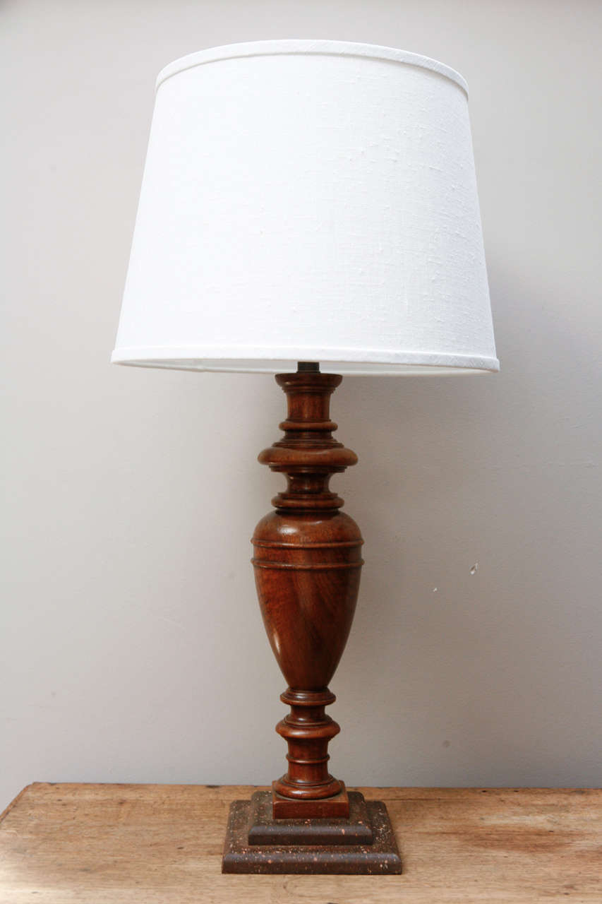 An urn shaped lamp in walnut with custom linen shade. Originating in France, dating to 1860. 