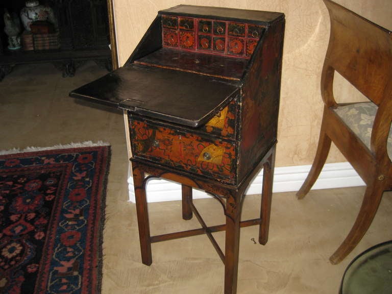 Small traveling desk with drop front writing surface above two drawers.  Chinese and English elements with a painted paper surface and custom made mahogany chinoiserie base.