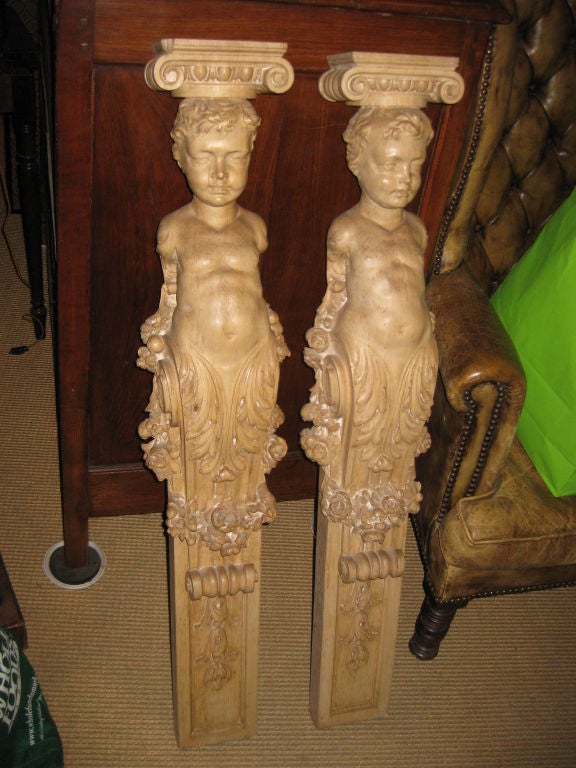 Large pair of wood corbals with carved faces and details