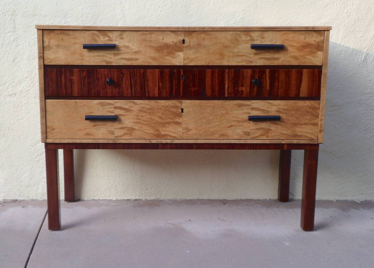 Swedish Art Deco chest of drawers or console in golden flame birch and rosewood. Top and sides are also in lively flame birch, pulls are ebonized wood and resin. Beautifully restored by our woodworkers. Made in Sweden, circa 1920.  The price listed