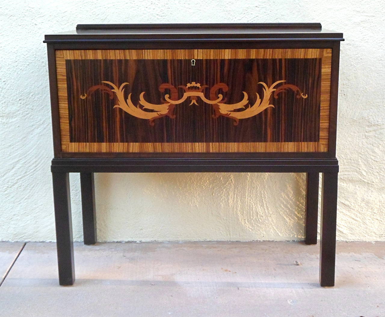 Swedish Art Deco era inlaid hall cabinet. Case in solid, stained birchwood. Inlaid door design, an enlarged scale neoclassical frieze, is rendered in zebrawood, rose wood, mahogany and pear. Interior in highly figured golden birch. Interior composed