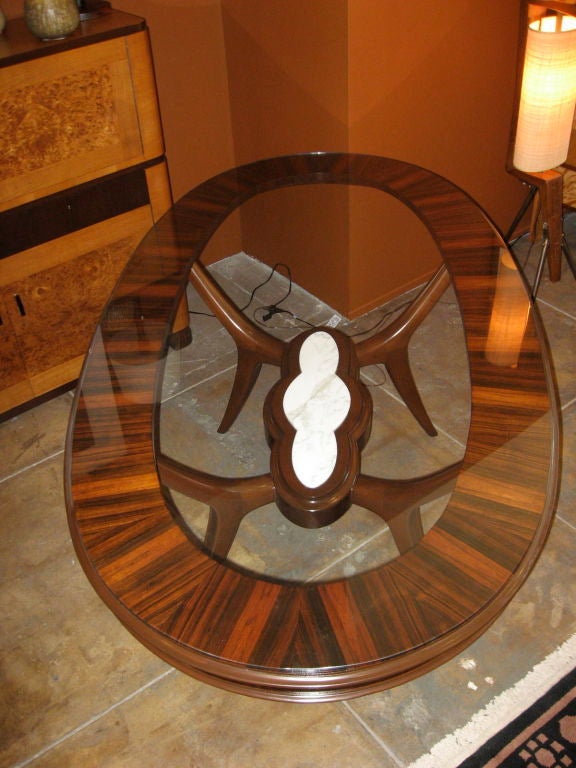 Mid-century modern oval dining table in rosewood and mahogany and marble. Glass top. Made at Bonta in Buenos Aires, Argentina in the 1950's.

The price listed is the FINAL NET price, which reflects a 50% reduction-extended through the Svenska